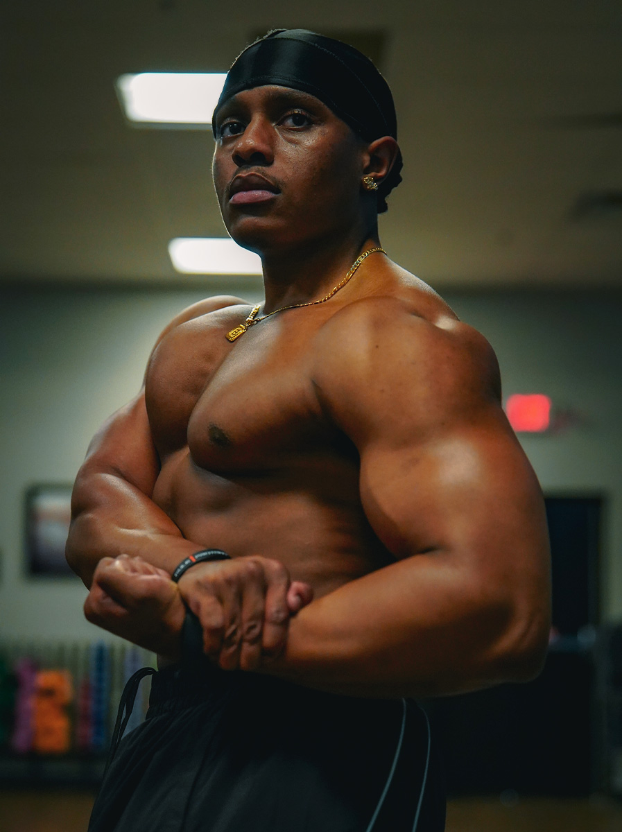 The coach flexing his chest and arm.